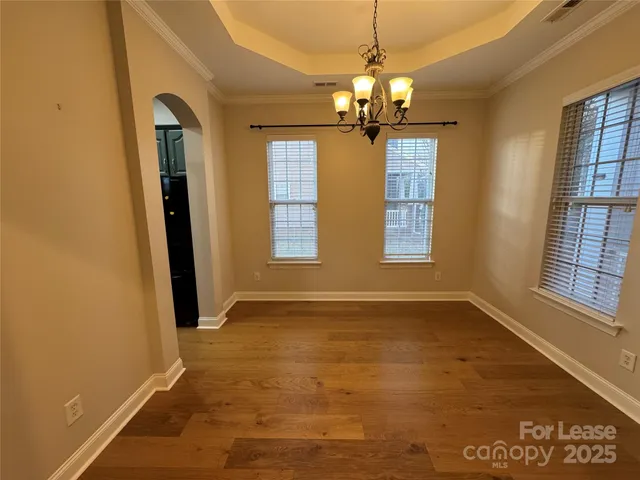 an empty room with chandelier and windows