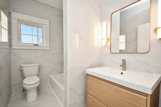 a white toilet sitting next to a bathroom sink