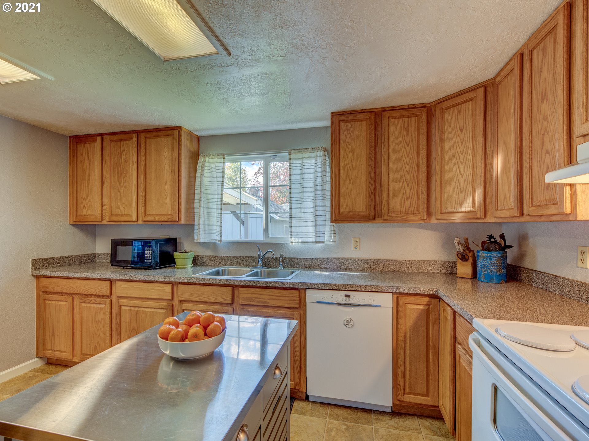 756 North 23rd Street Springfield, OR 97477 - Photo 4 of 22 a kitchen with stainless steel appliances a sink a stove cabinets counter space and a window