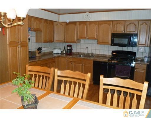 161 East Hill Road Colonia, NJ 07067 - Photo 4 of 16 a kitchen with stainless steel appliances wooden cabinets a stove top oven a sink and dishwasher