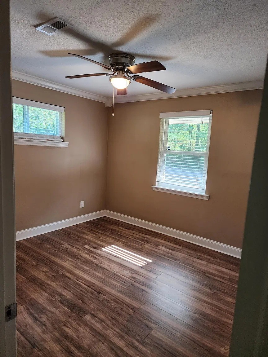 3836 Youngstown Road Chattanooga, TN 37406 - Photo 5 of 7 an empty room with wooden floor fan and windows