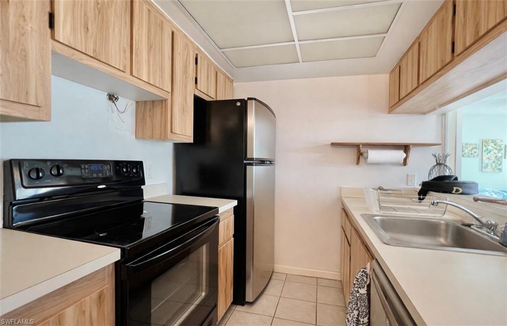 4293 27th Court Southwest, Unit 203 Naples, FL 34116 - Photo 11 of 22 a kitchen with a sink stove and refrigerator