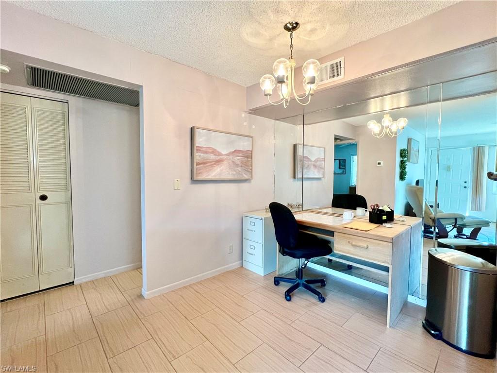 4293 27th Court Southwest, Unit 203 Naples, FL 34116 - Photo 11 of 26 a view of a workspace with furniture and a chandelier