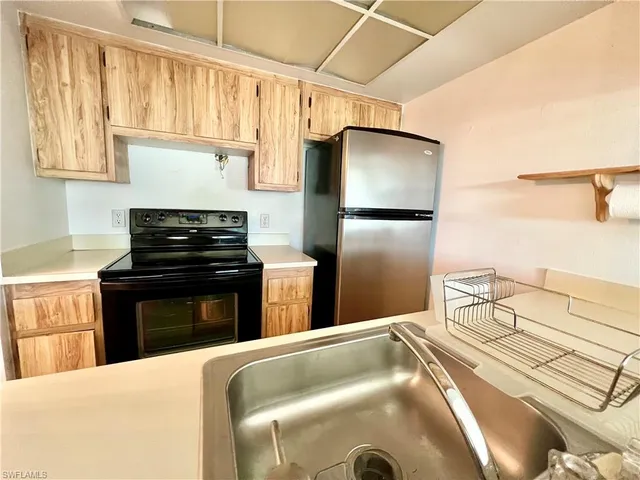 a kitchen with a refrigerator and a stove top oven