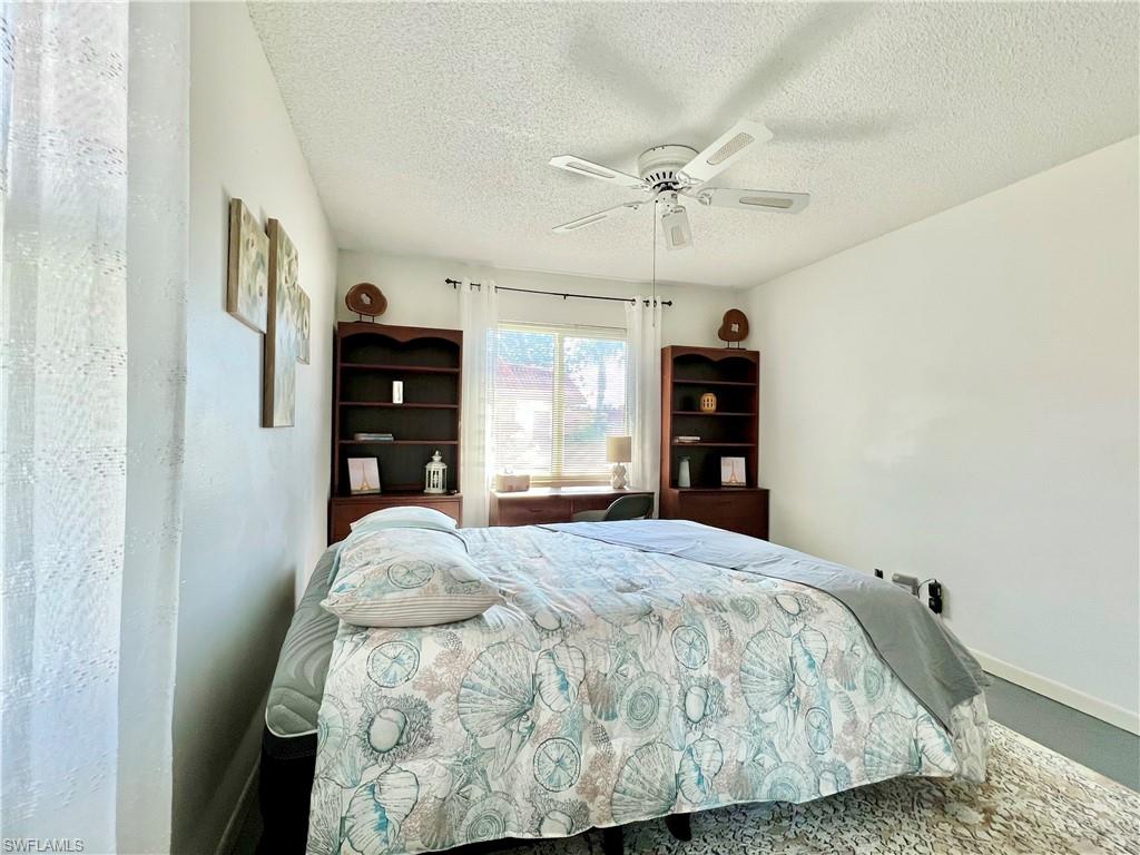 4293 27th Court Southwest, Unit 203 Naples, FL 34116 - Photo 19 of 26 a bedroom with a bed and a flat tv screen