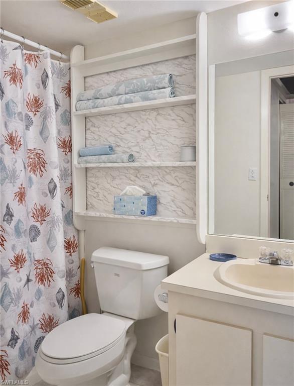 4293 27th Court Southwest, Unit 203 Naples, FL 34116 - Photo 19 of 22 a bathroom with a sink a toilet and a shower curtain