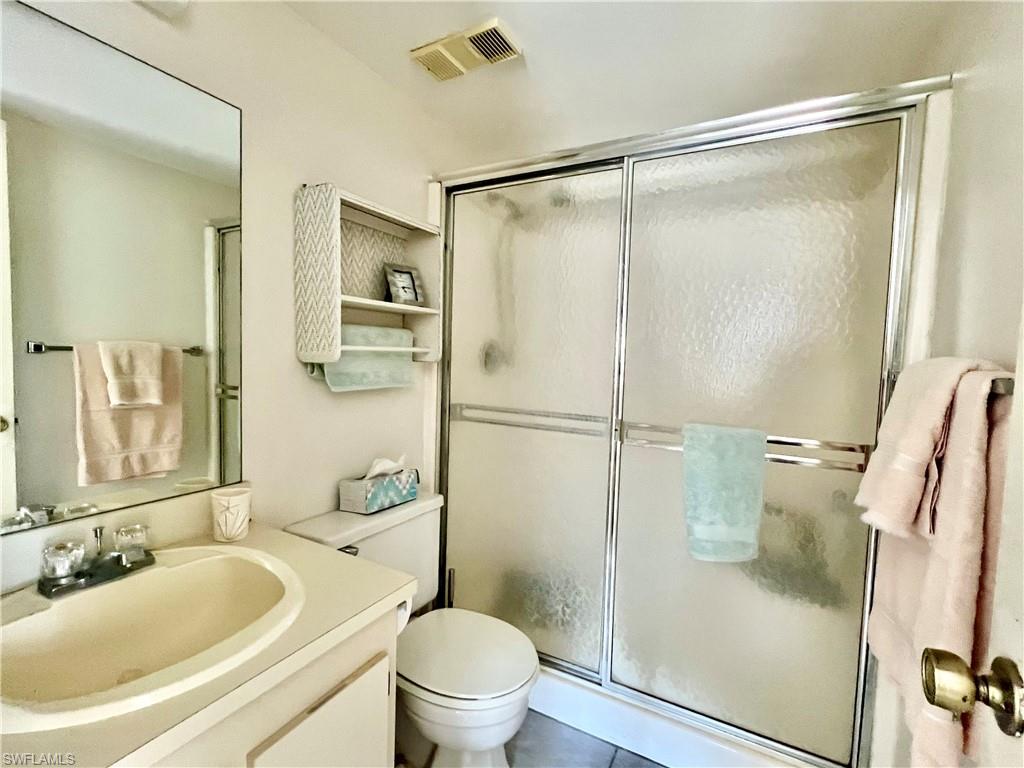 4293 27th Court Southwest, Unit 203 Naples, FL 34116 - Photo 21 of 26 a bathroom with a granite countertop sink toilet and shower