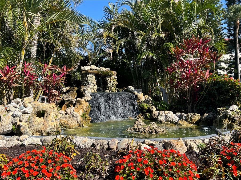 4293 27th Court Southwest, Unit 203 Naples, FL 34116 - Photo 23 of 26 a bunch of flowers are in a yard