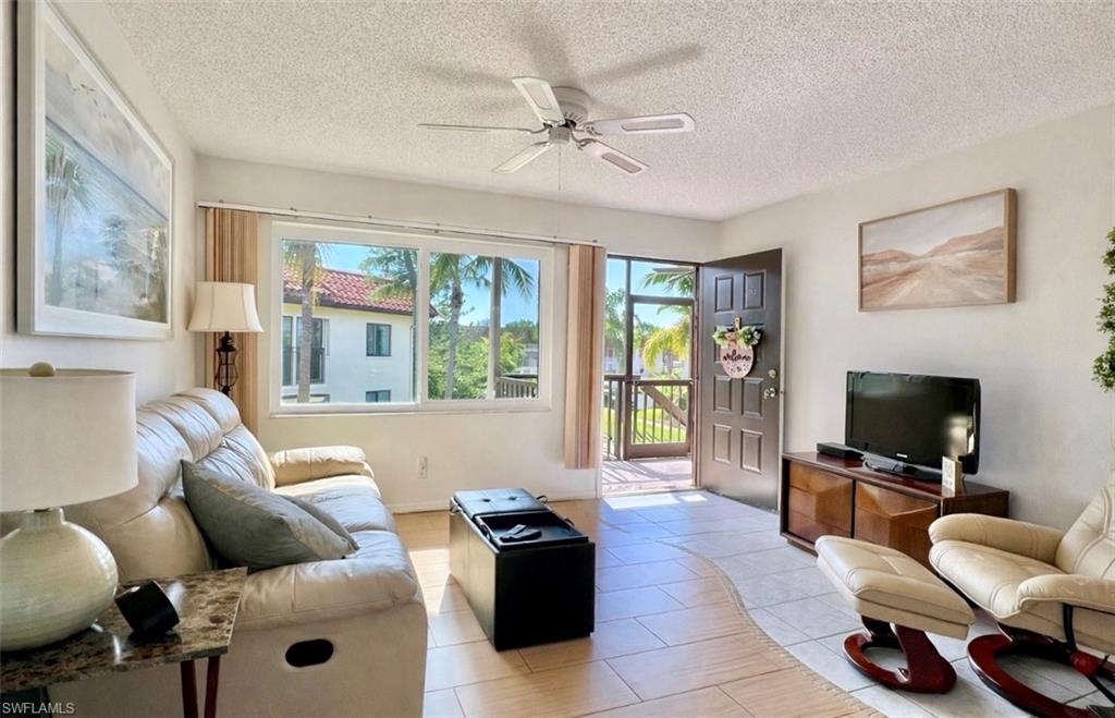 4293 27th Court Southwest, Unit 203 Naples, FL 34116 - Photo 5 of 22 a living room with furniture and a flat screen tv