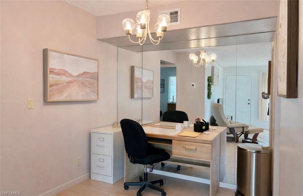 4293 27th Court Southwest, Unit 203 Naples, FL 34116 - Photo 10 of 22 a view of a workspace with furniture and a chandelier