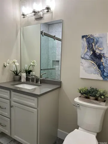 a bathroom with a toilet sink and mirror