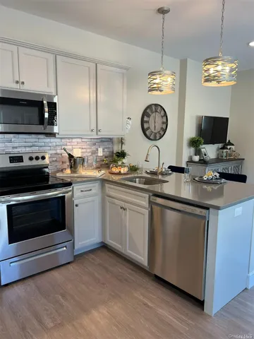 a kitchen with stainless steel appliances granite countertop a stove a sink and a microwave