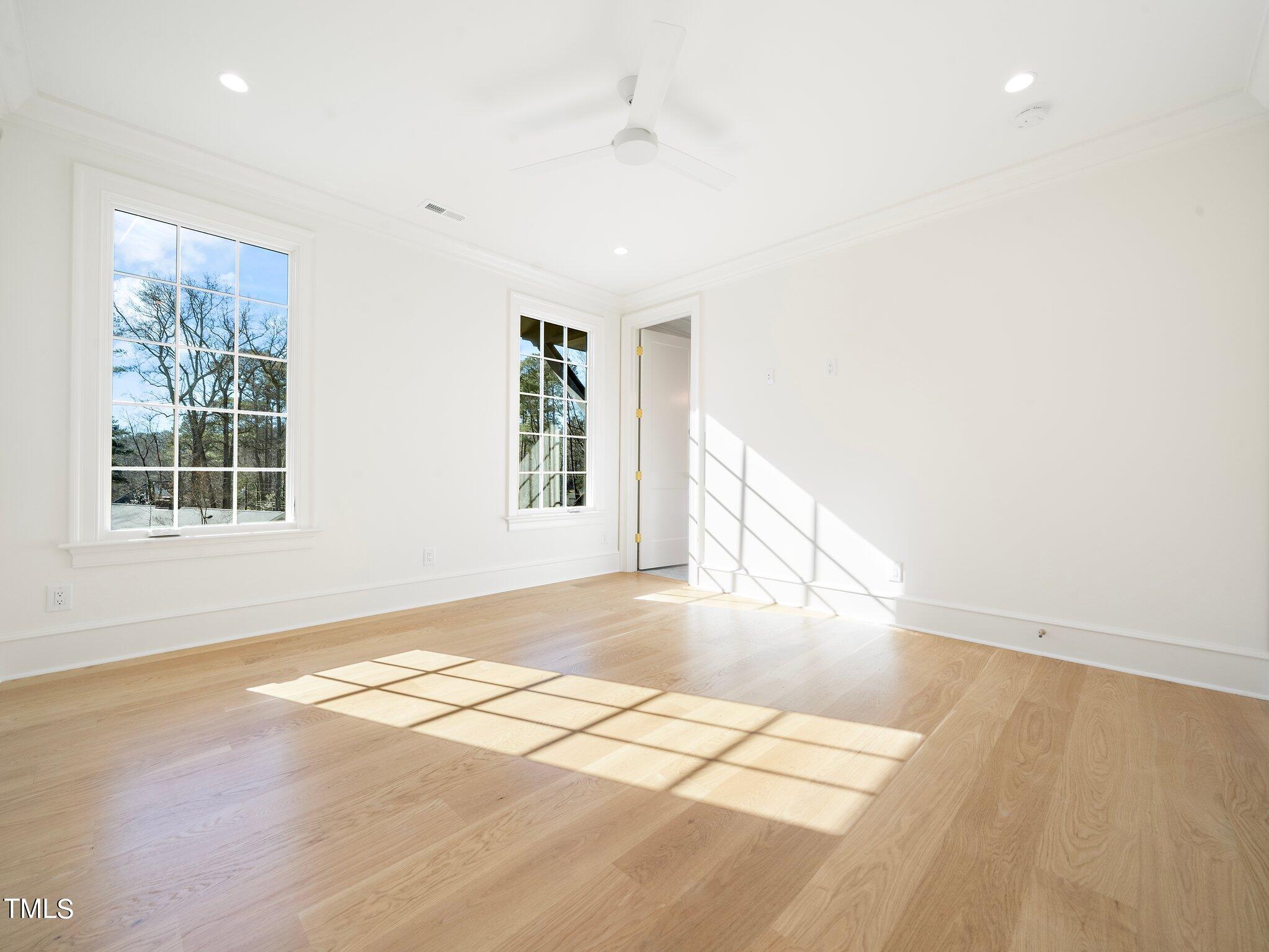 5400 Alpine Drive Raleigh, NC 27609 - Photo 51 of 70 an empty room with wooden floor and windows