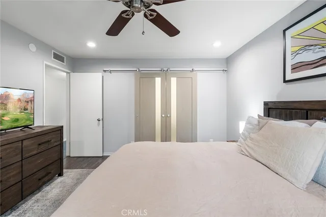 a bedroom with a large bed and flat tv screen