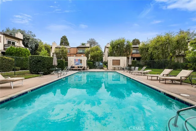a view of a swimming pool and lounge chairs in patio