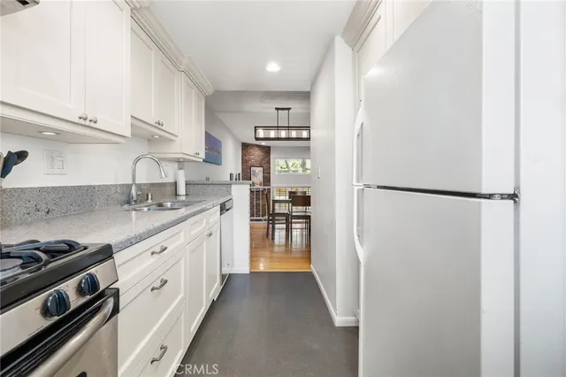 a kitchen with stainless steel appliances granite countertop a refrigerator and a sink