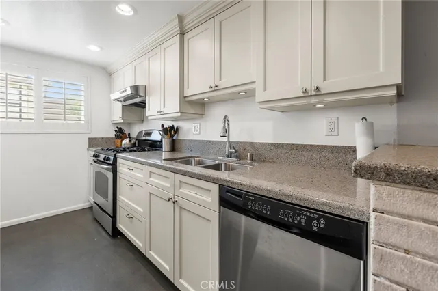 a kitchen with stainless steel appliances granite countertop a sink stove and cabinets