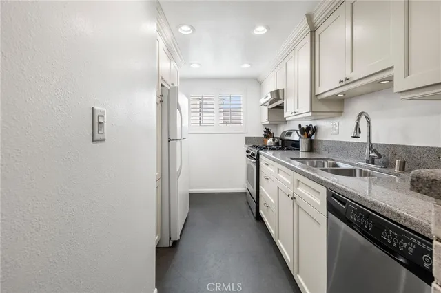 a kitchen with stainless steel appliances a sink stove and cabinets