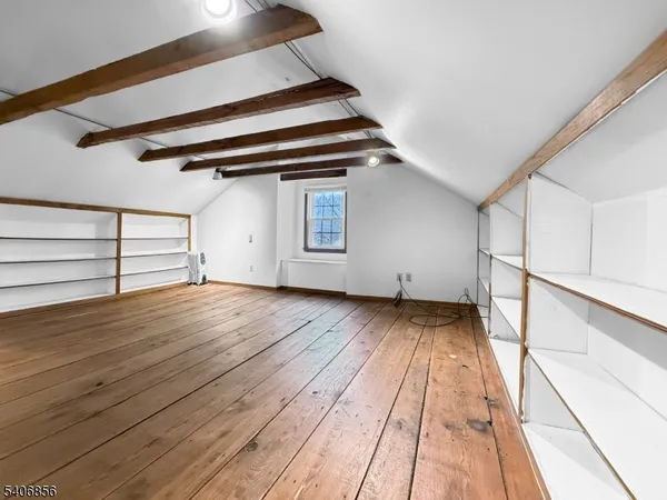 a view of a room with wooden floor and cabinets