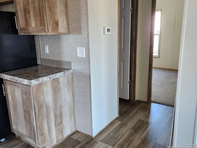 a bathroom with a granite countertop double vanity sink a mirror and a toilet