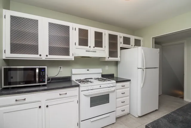 a kitchen with stainless steel appliances white cabinets and a stove top oven