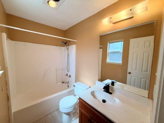 2604 Crix Lane Fort Worth, TX 76140 - Photo 9 of 13 Bathroom featuring a white bathtub and shower combination, a toilet, and a vanity with an integrated sink