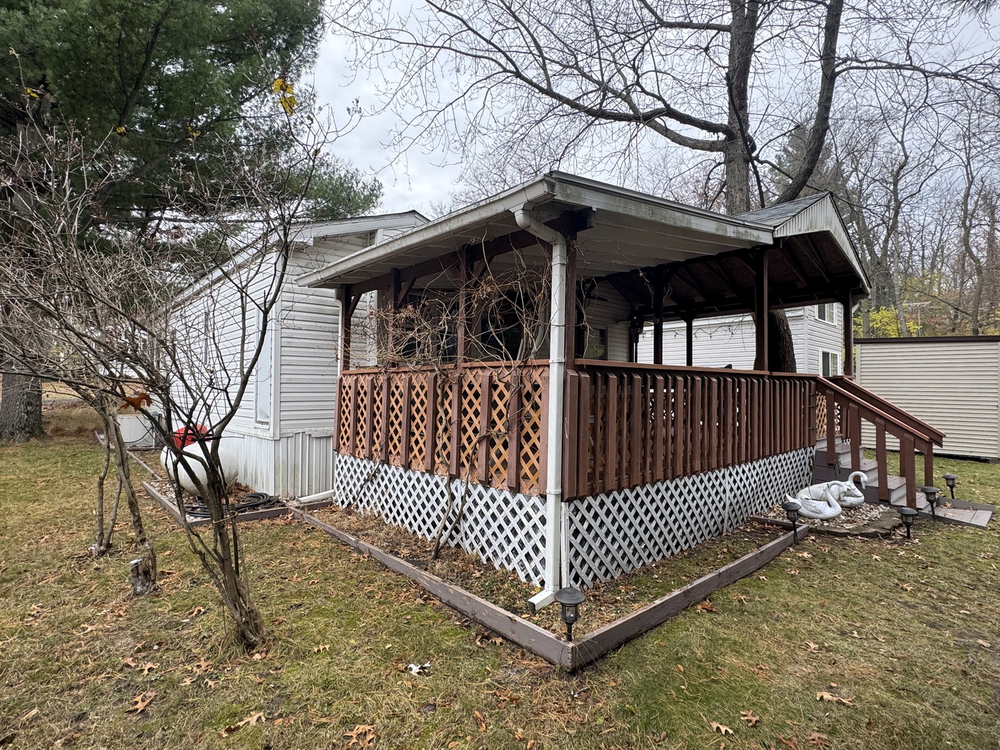 21-211 Woodhaven Lakes Sublette, IL 61367 - Photo 3 of 17 a view of wooden house with large trees and wooden fence