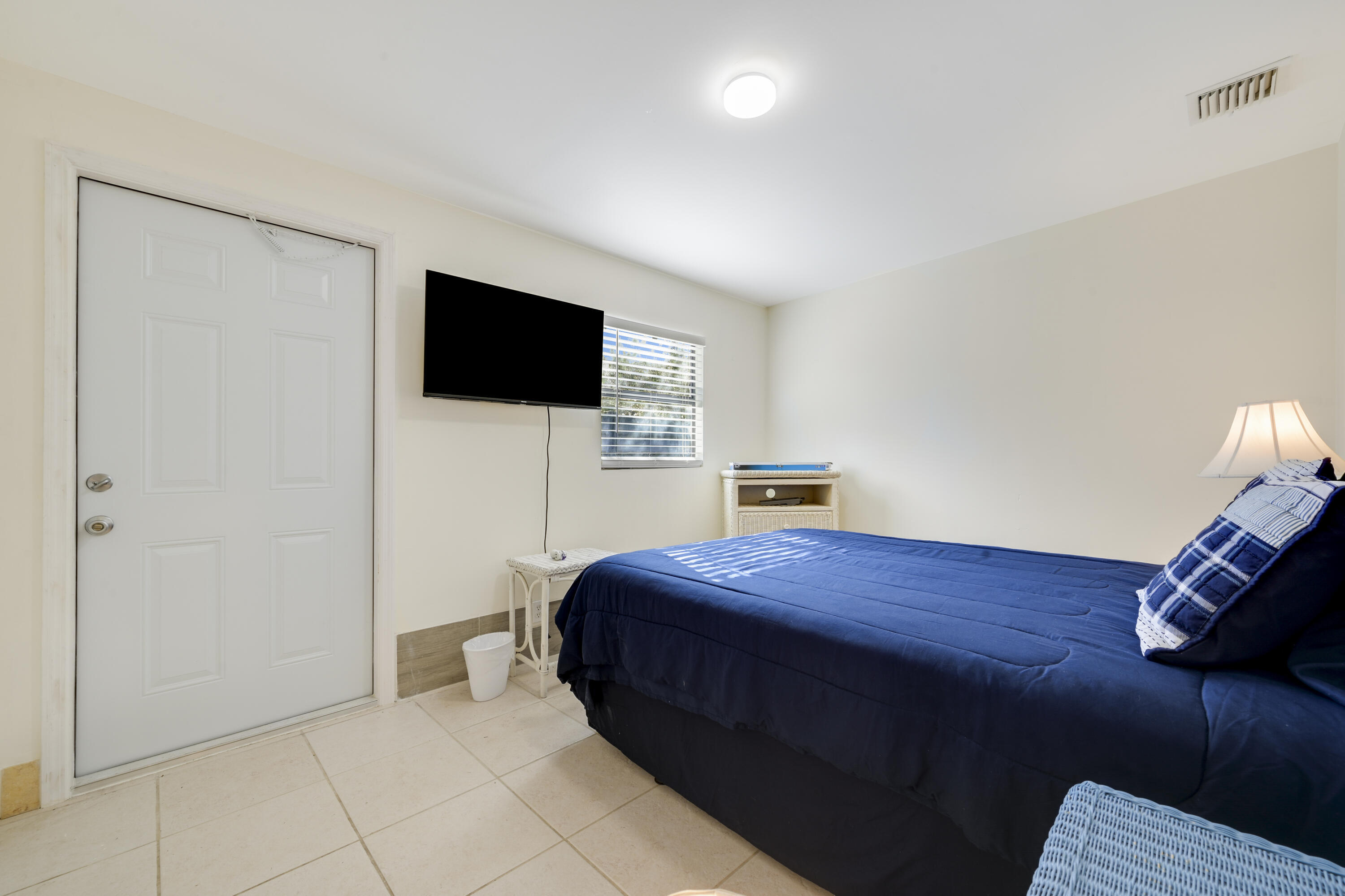 1718 Ridge Road North Palm Beach, FL 33408 - Photo 12 of 39 a bedroom with a bed and a flat screen tv