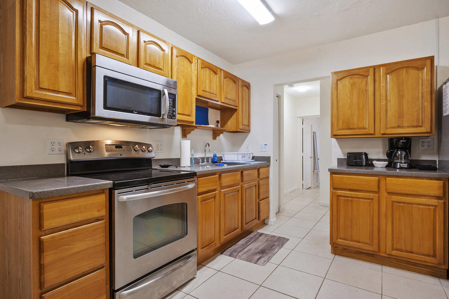 1718 Ridge Road North Palm Beach, FL 33408 - Photo 4 of 39 a kitchen with stainless steel appliances granite countertop a stove top oven microwave and cabinets