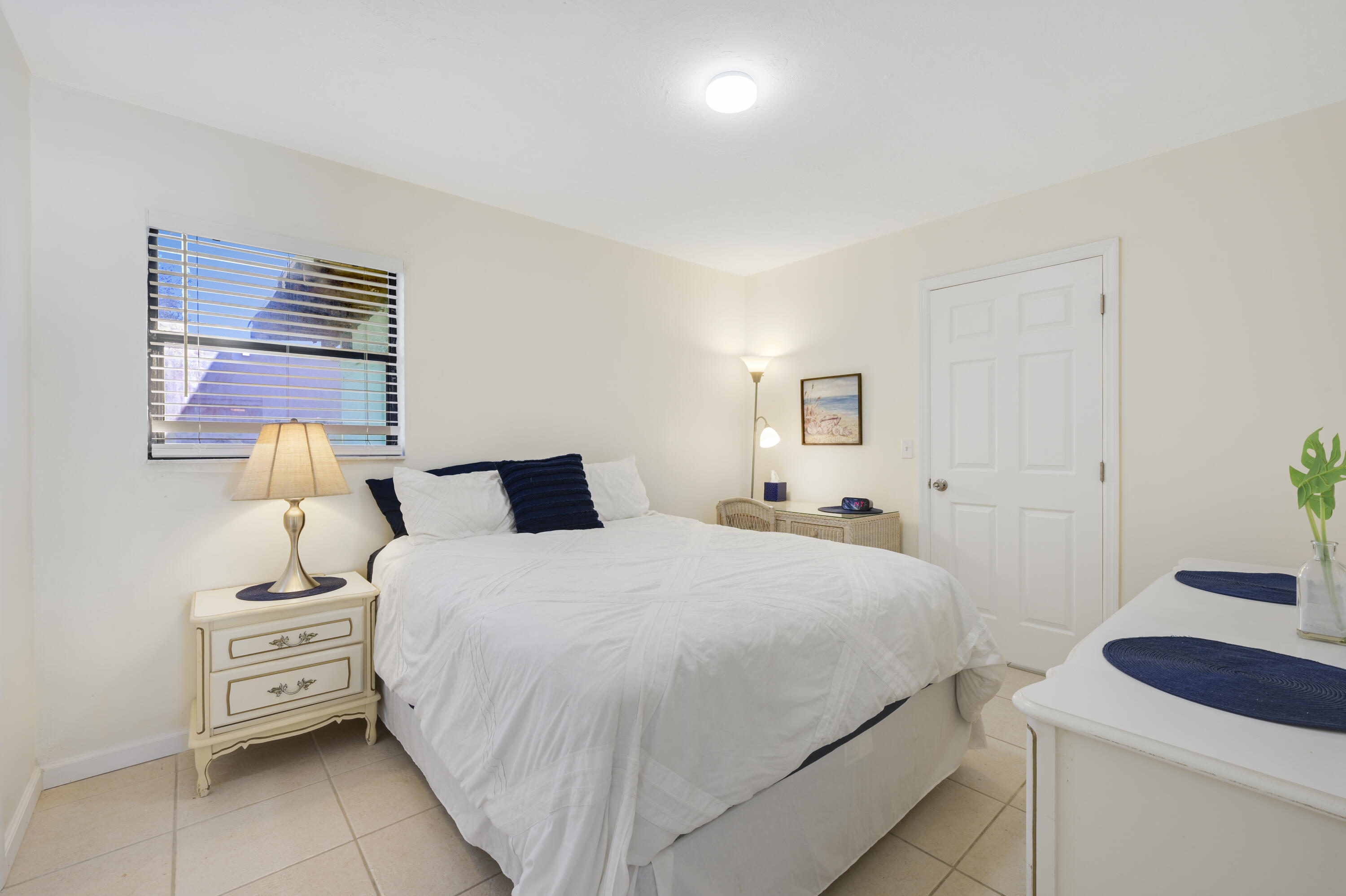 1718 Ridge Road North Palm Beach, FL 33408 - Photo 7 of 39 a bedroom with a bed and a lamp