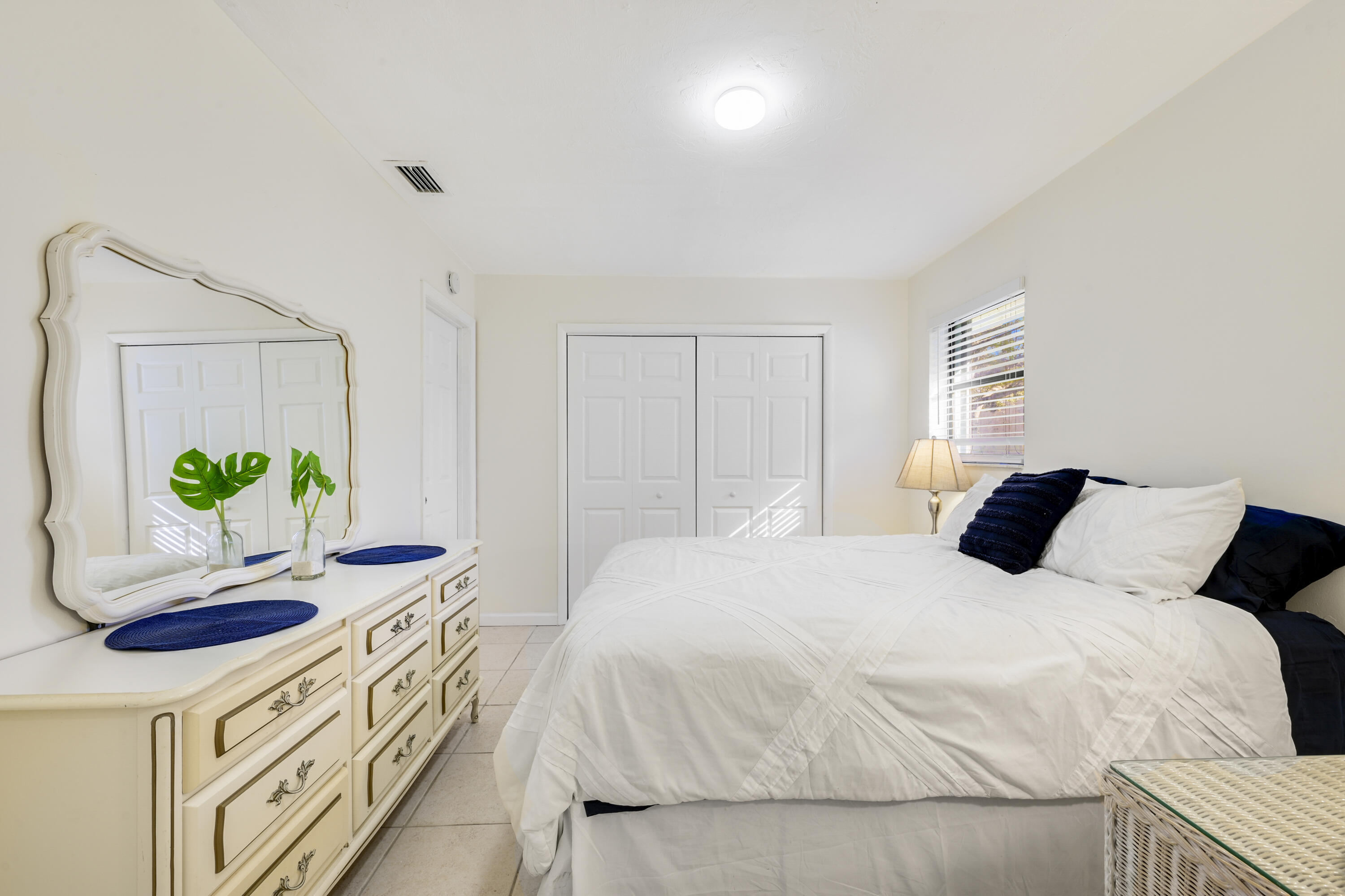 1718 Ridge Road North Palm Beach, FL 33408 - Photo 8 of 39 a bedroom with a bed and a potted plant