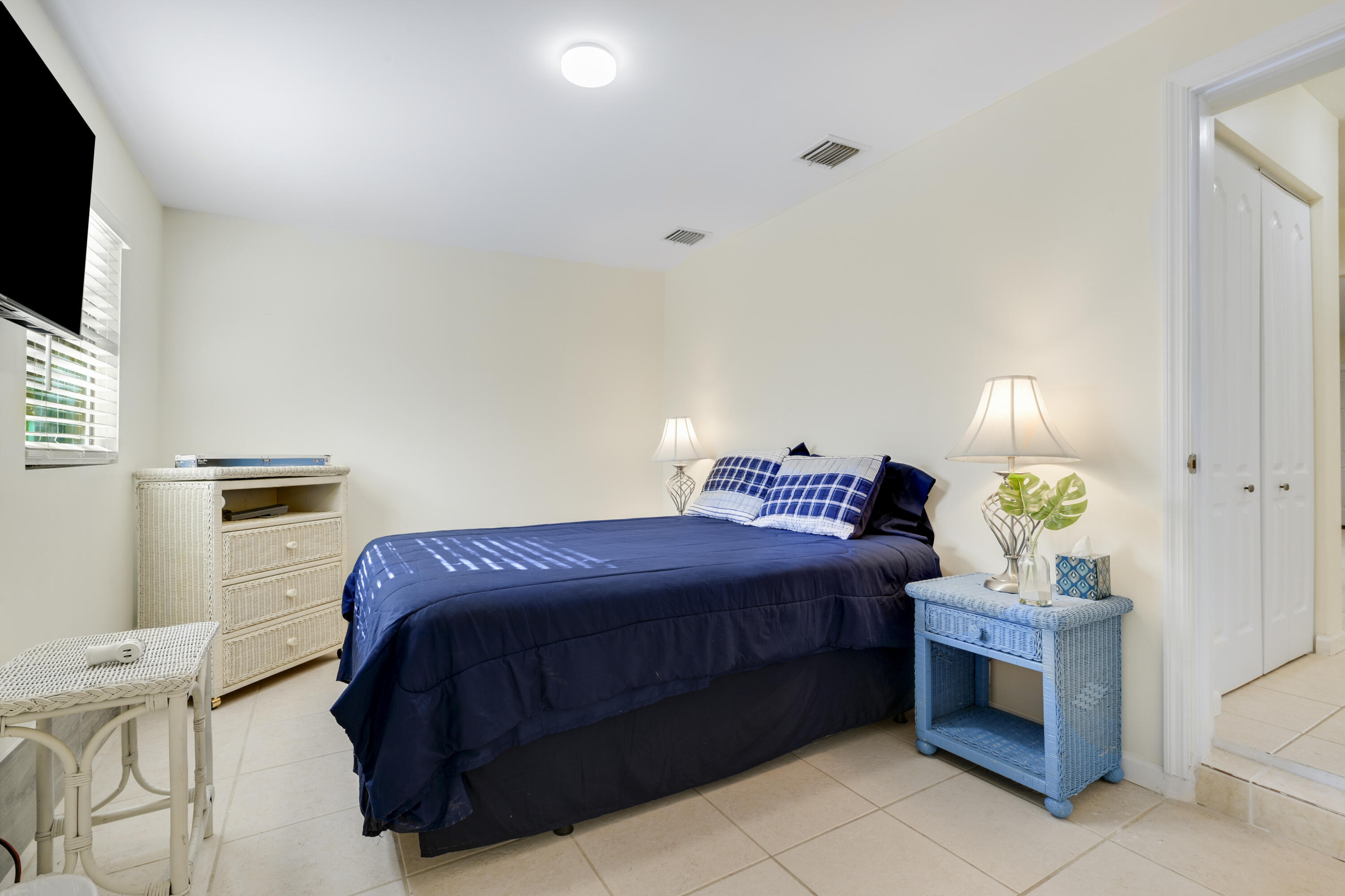 1718 Ridge Road North Palm Beach, FL 33408 - Photo 10 of 39 a bedroom with a bed and a flat screen tv