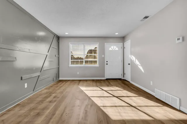 a view of a livingroom with wooden floor and white doors