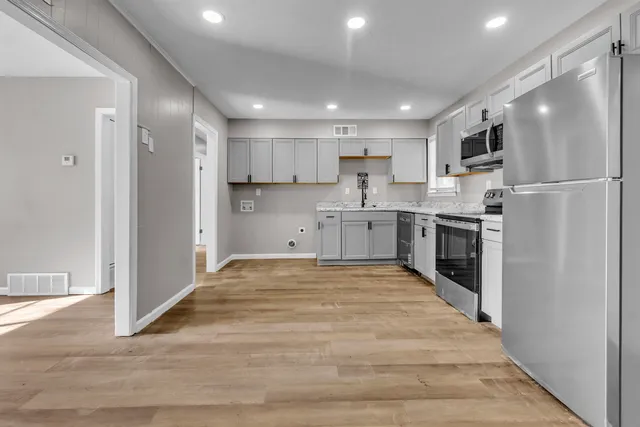 a large kitchen with cabinets and stainless steel appliances