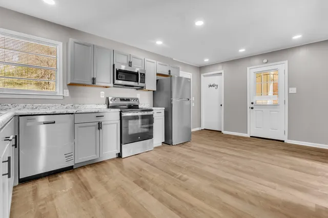 a kitchen with stainless steel appliances granite countertop a stove a sink and a refrigerator
