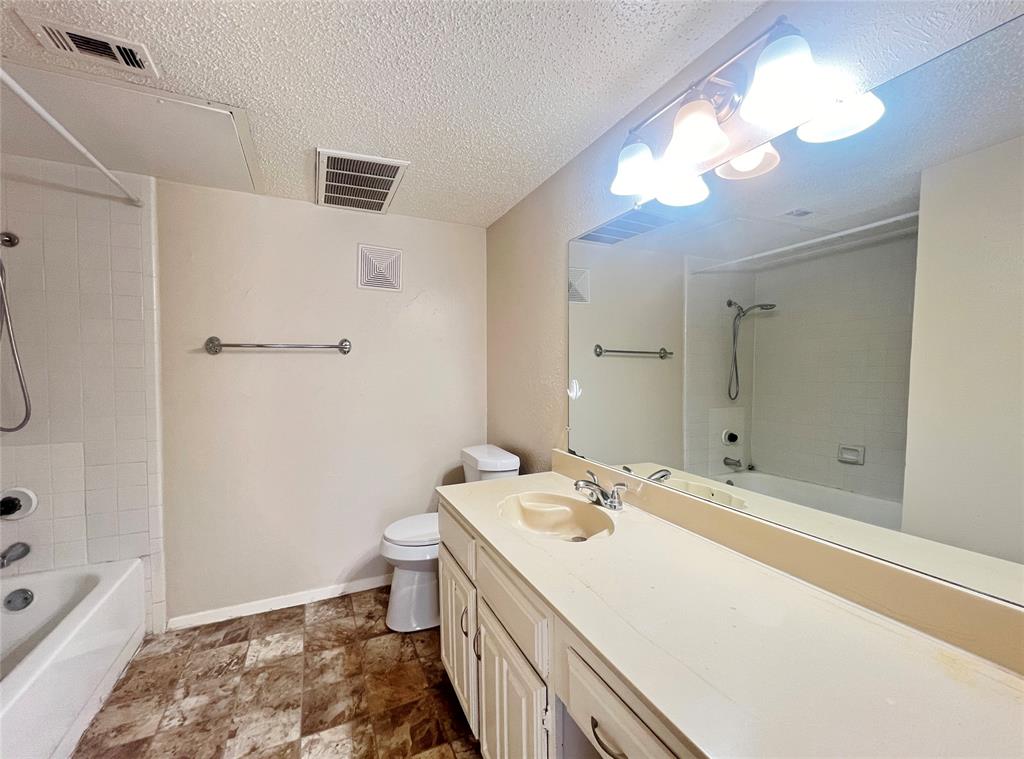 5626 Preston Oaks Road, Unit 43D Dallas, TX 75254 - Photo 5 of 9 a bathroom with a sink a toilet and a mirror
