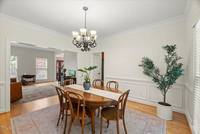 a living room with furniture a dining table and a potted plant