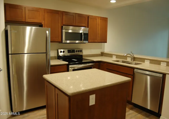 a kitchen with a sink a refrigerator a microwave a sink and cabinets
