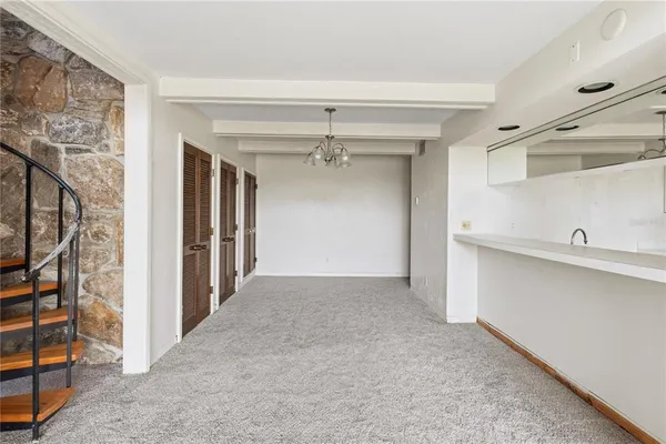 a view of a hallway with closet and chandelier