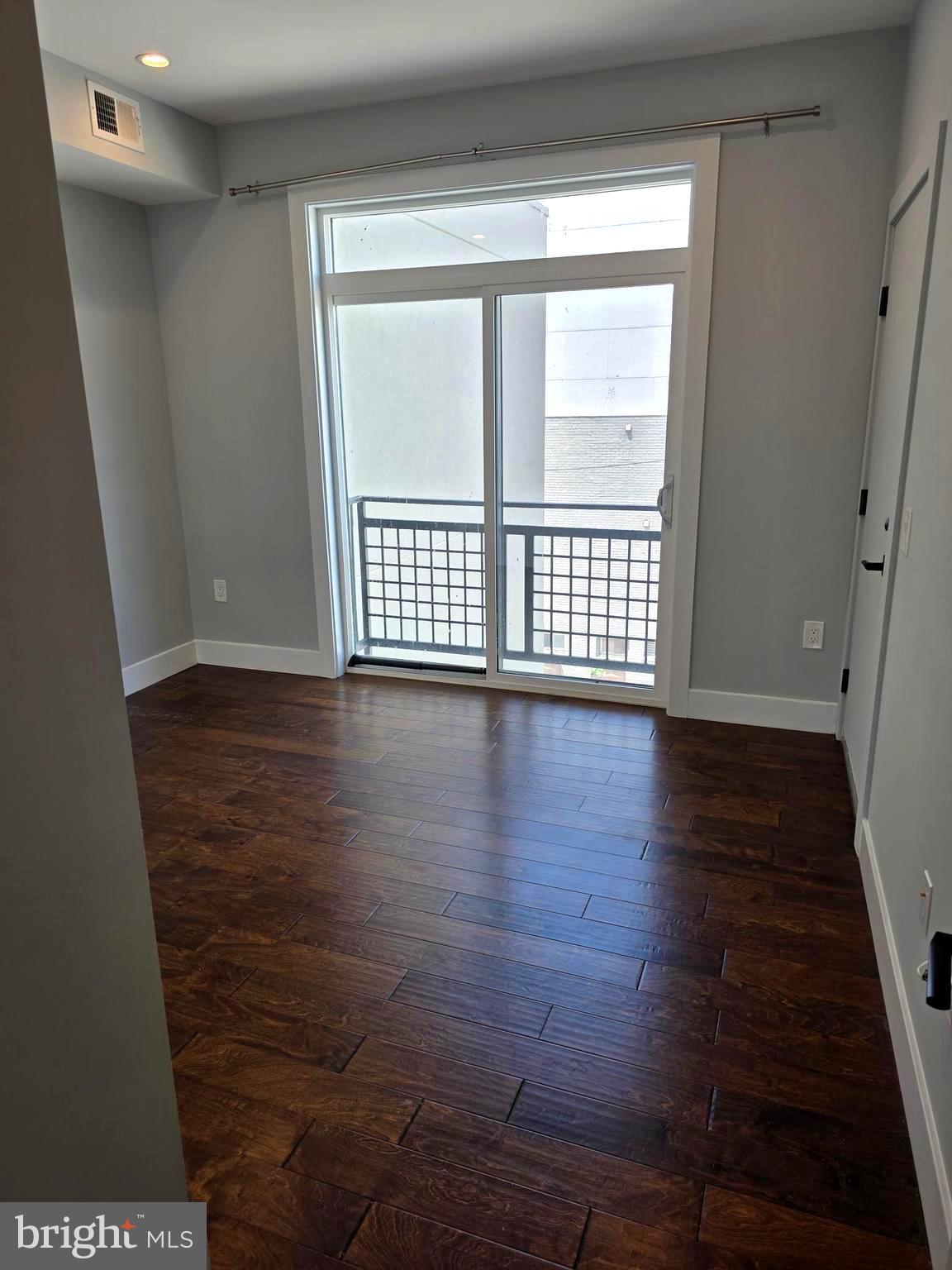 1101 Fern Street Northwest, Unit 301 Washington, DC 20012 - Photo 21 of 25 a view of an empty room with wooden floor and a window