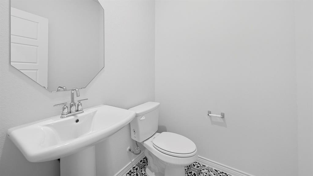 3405 Bar Claims Street Aubrey, TX 76227 - Photo 7 of 38 a bathroom with a sink a toilet and a mirror