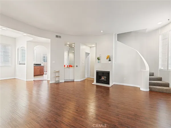 an empty room with wooden floor and fireplace