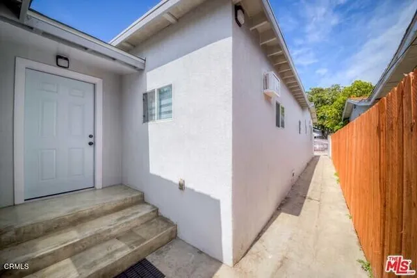a view of a house with backyard and wooden fence