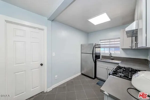 a kitchen with a refrigerator and a stove top oven
