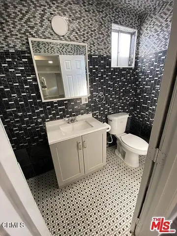 a bathroom with a toilet a sink and a mirror