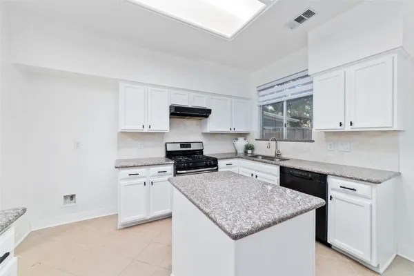 a kitchen with a stove a sink dishwasher and a refrigerator