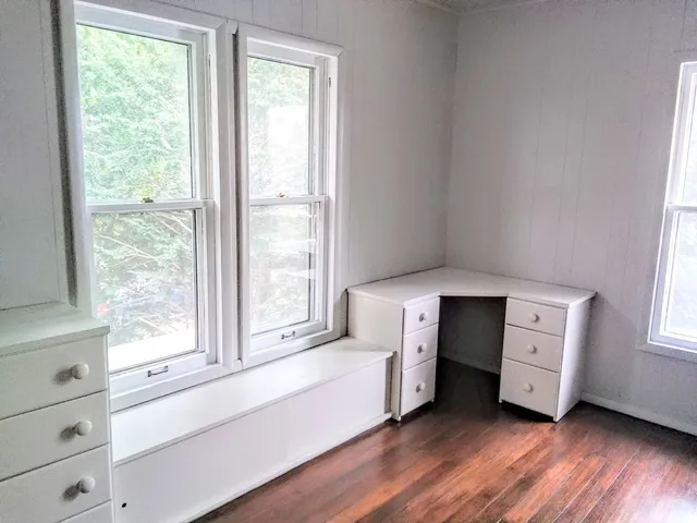 a spacious bedroom with a bed and a large window