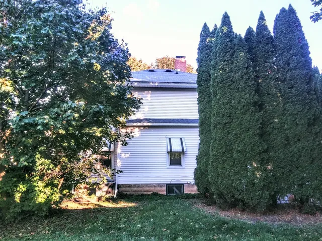 a view of a house with a yard and a tree