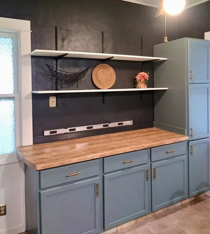a view of a room with wooden floor a fireplace and windows