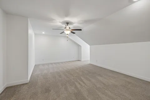 a view of an empty room with a chandelier fan